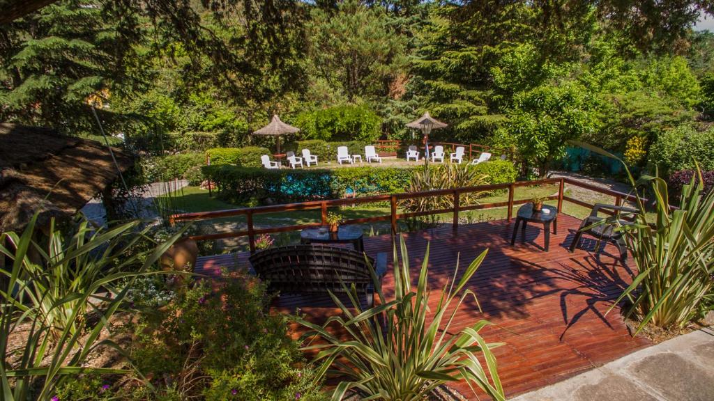 una terraza de madera con sillas y mesas en un jardín en Terrazas de Cruz Chica. en La Cumbre