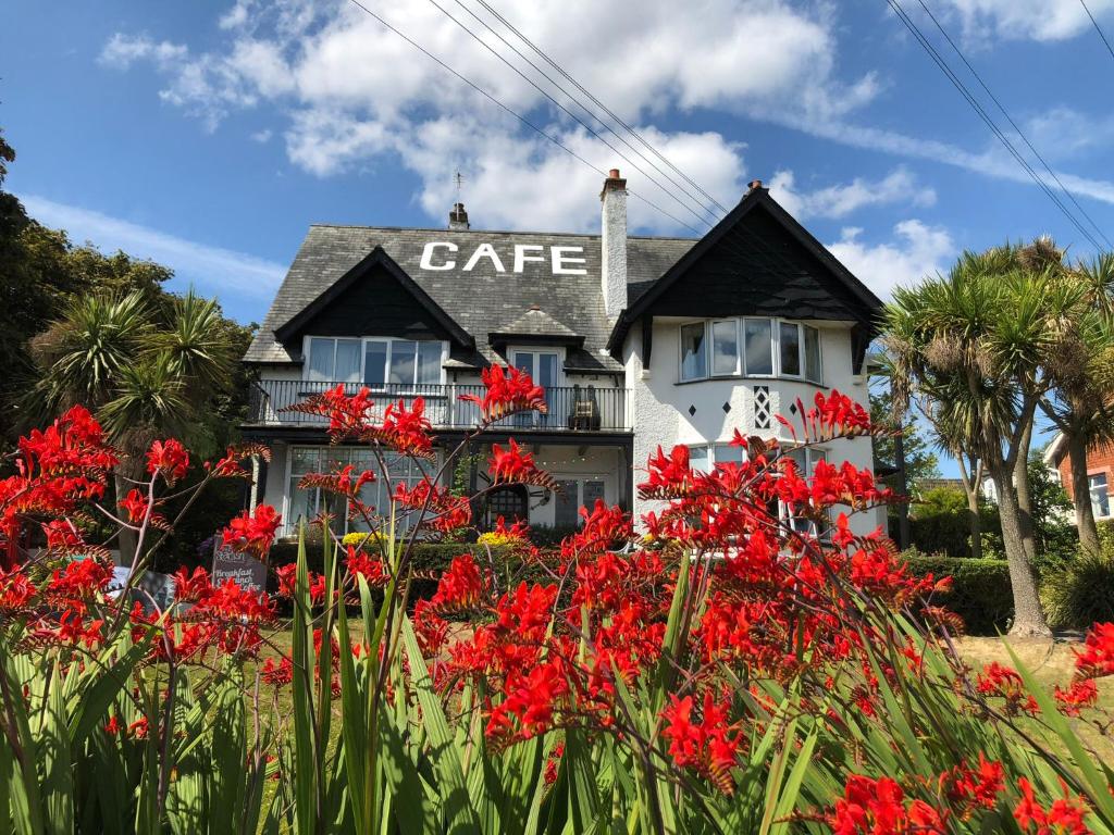 una casa con flores rojas delante de ella en Cairn Bay Lodge en Bangor