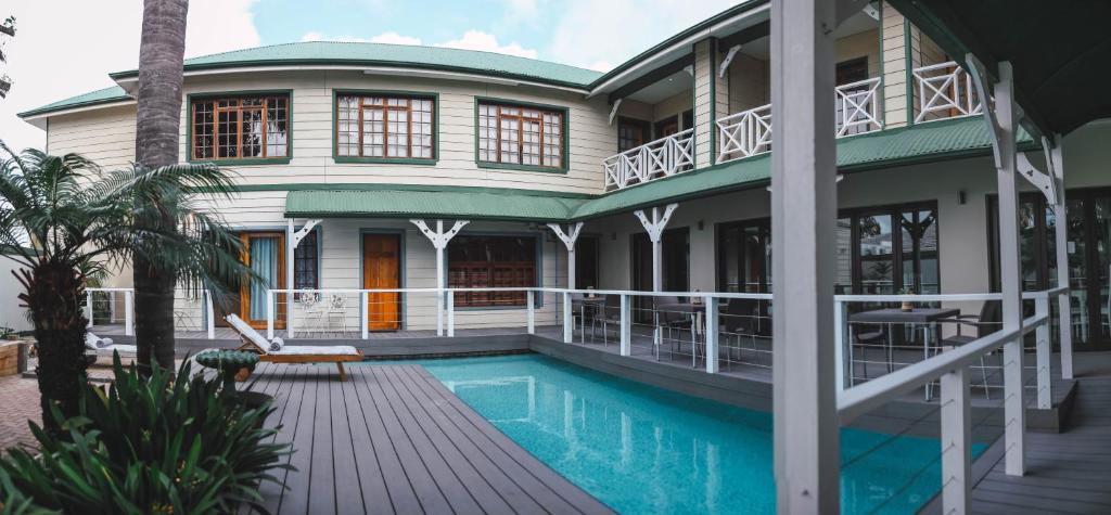 a house with a swimming pool in front of it at Victoria and Alfred Guest House in Port Elizabeth