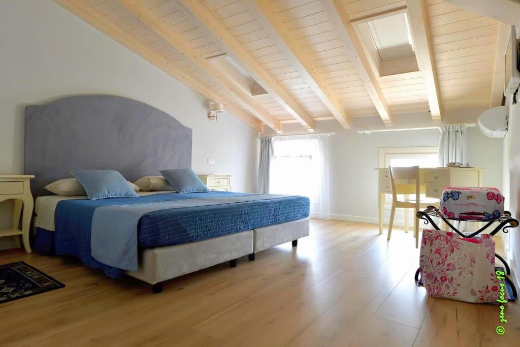 een slaapkamer met een bed, een tafel en een stoel bij Spagnoi Rooms in Castelnuovo del Garda