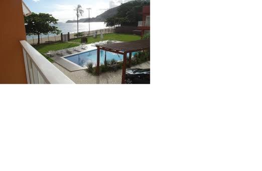 a balcony with a table and a view of the ocean at Pé na areia em Boiçucanga condominio Aquamarine - perto de Maresias e Camburi in Boicucanga