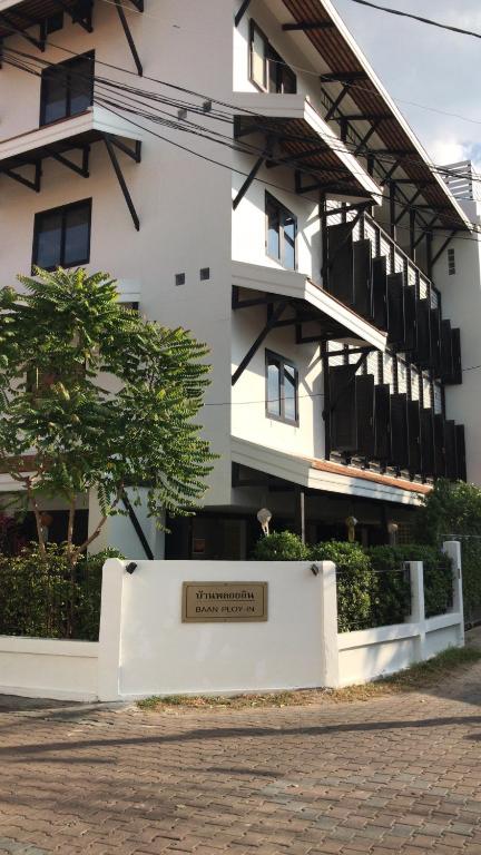 a white building with a sign in front of it at Baan Ploy In in Chiang Mai