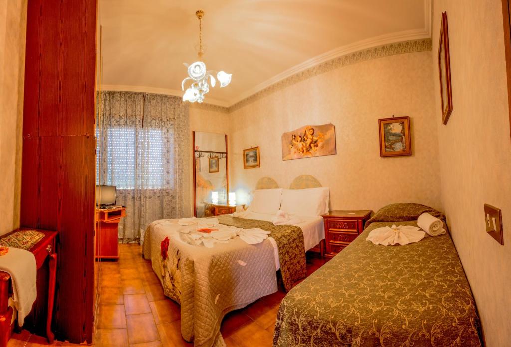 菲烏米奇諾的住宿－希拉里旅館，酒店客房设有两张床和吊灯。