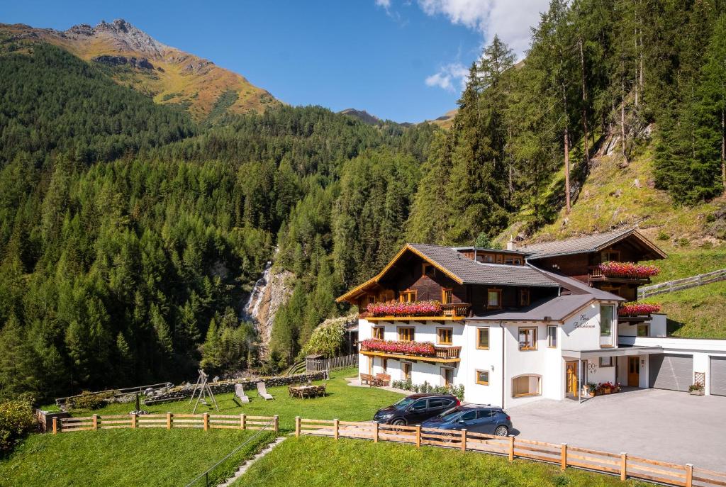 een huis in de bergen met twee auto's geparkeerd bij Haus Dabaklamm in Kals am Großglockner