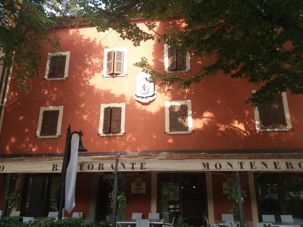 Piobbico的住宿－Albergo Montenerone，前面有标志的红色建筑