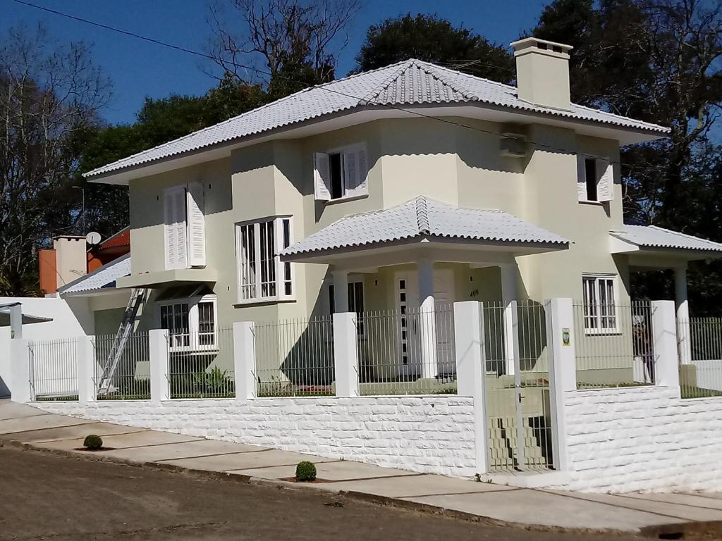 a white house with a white fence at CASA JE - Santa Cruz do Sul in Santa Cruz do Sul