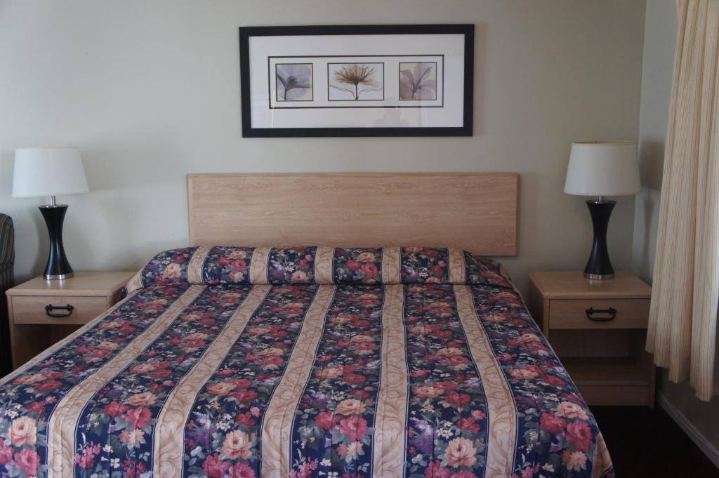 a bedroom with a bed with a quilt on it at Budget Inn in El Cerrito