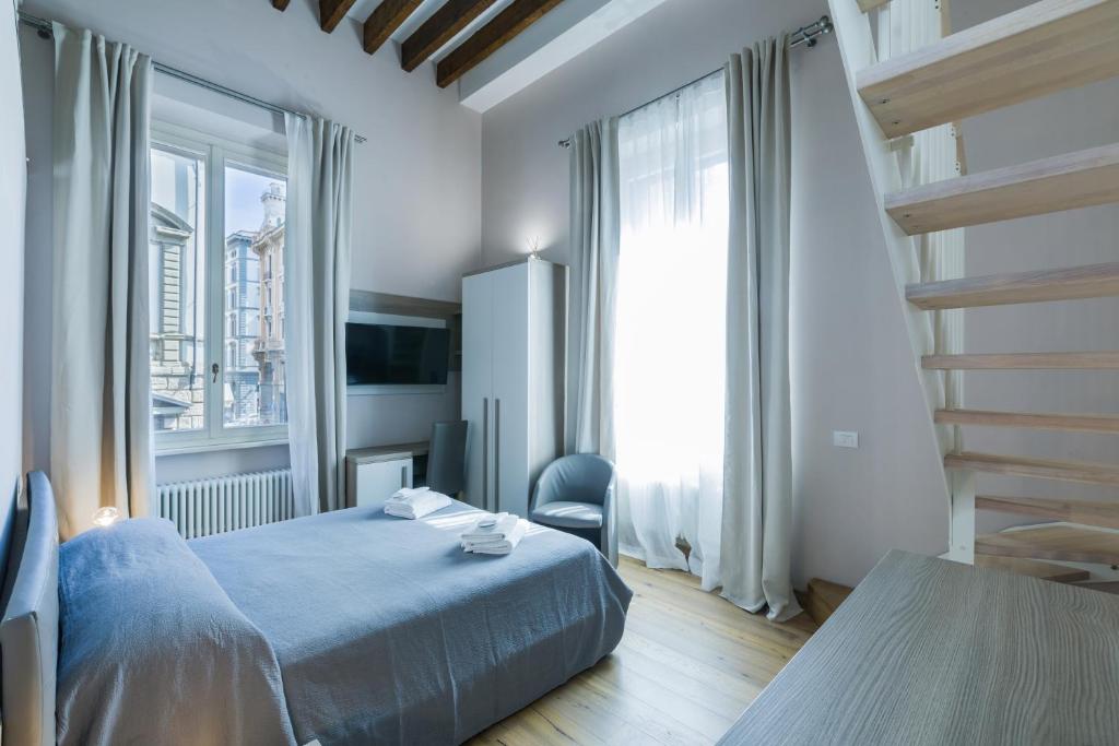 a bedroom with a bed and a chair and a window at VRooms All'Angolo Del Duomo in Florence