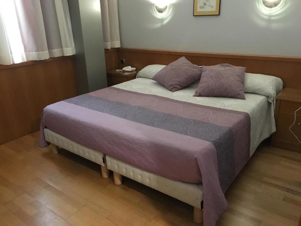 1 dormitorio con 1 cama con 2 almohadas en Encasa Hotel Almansa, en Almansa