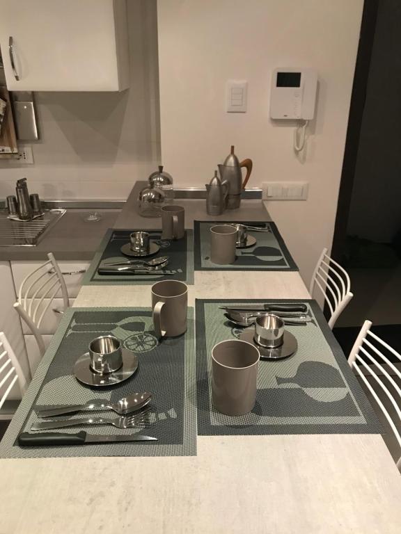 a kitchen table with plates and utensils on it at Bari Lory’s Home in Bari