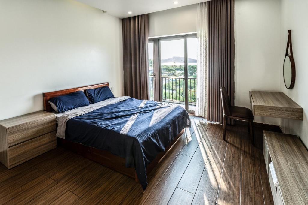 a bedroom with a bed and a desk and a window at Homestay Villa Full House in Ha Long