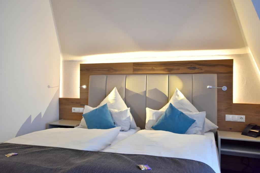 a bedroom with a large bed with blue and white pillows at Hotel & Restaurant Zum Deutschen Hause in Kirchhatten