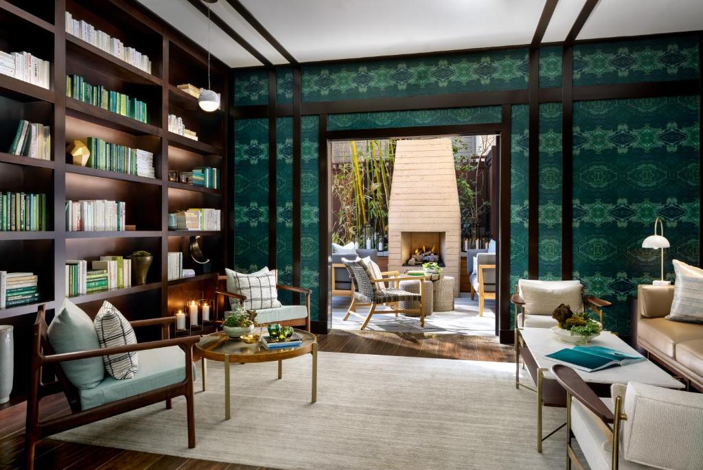a living room with bookshelves and a fireplace at Ambrose Hotel in Los Angeles