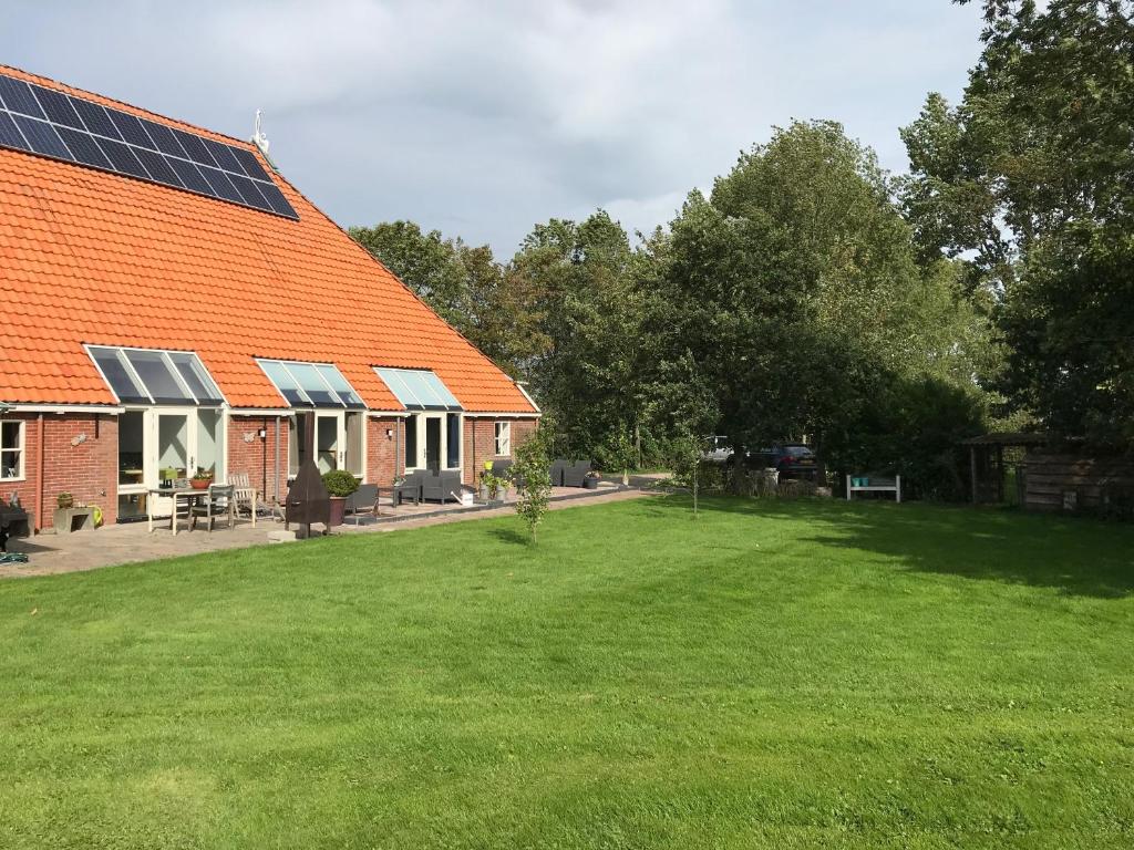 an orange roofed house with solar panels on it at Altenburgpleats in Hempens