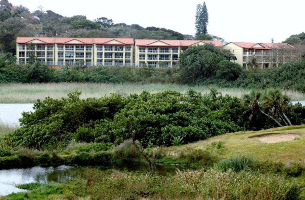 un gran edificio frente a una masa de agua en Kingfisher E, en Shelly Beach