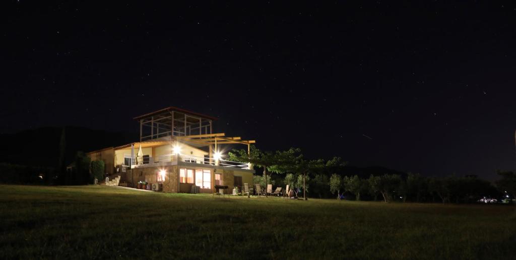 une grande maison dans un champ la nuit dans l'établissement Zoina's House, à Leptokaryá