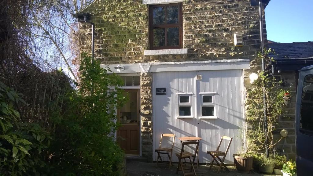 a shed with a table and chairs in front of a house at Old Coach House - "Loved staying here" in Sheffield