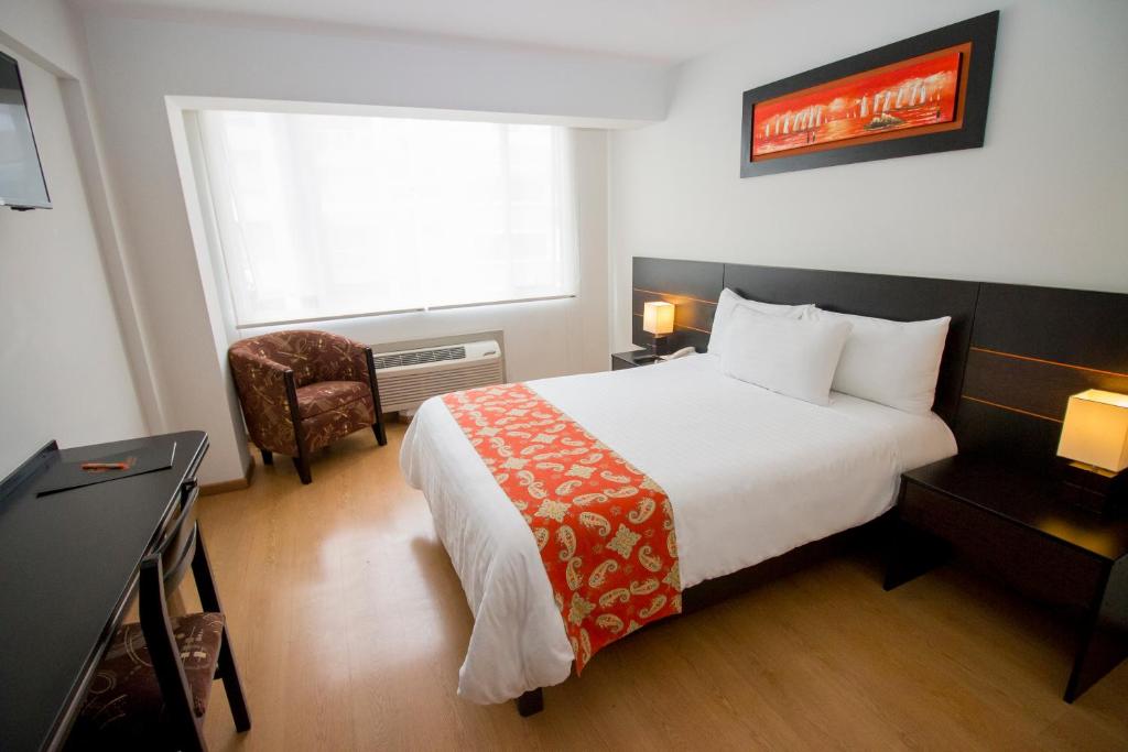 una camera d'albergo con letto e finestra di Hotel Britania Miraflores a Lima