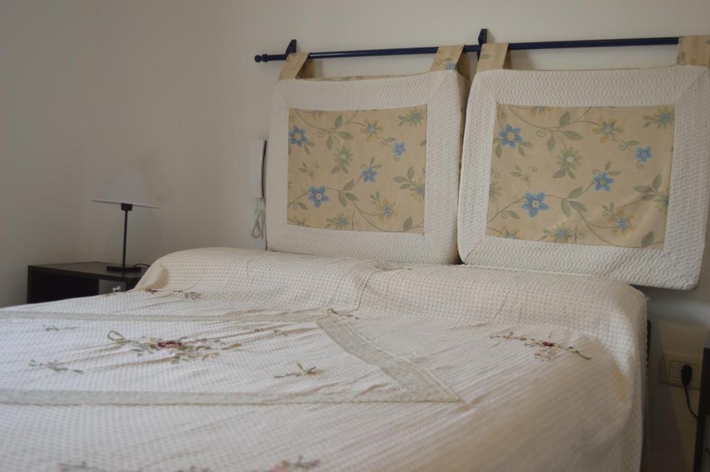 1 dormitorio con 1 cama blanca con sábanas y almohadas blancas en Duplex Lisandro en San Rafael