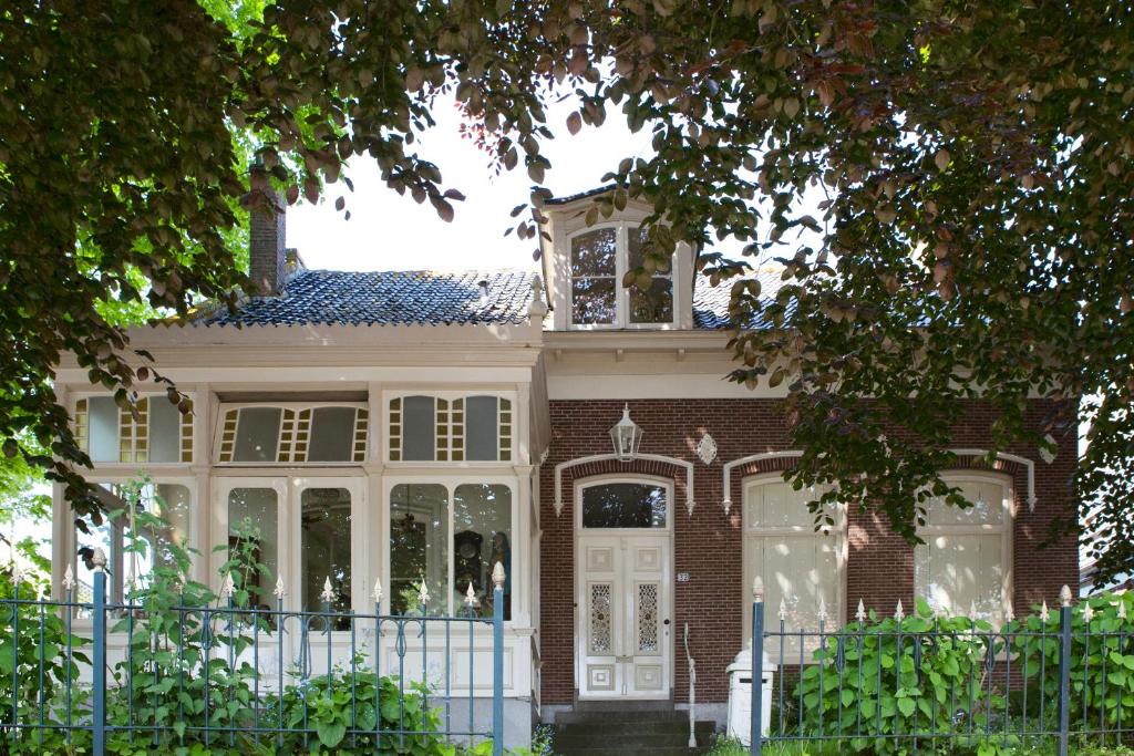 una casa con una cerca blanca delante de ella en Patricius House, en Oostwoud