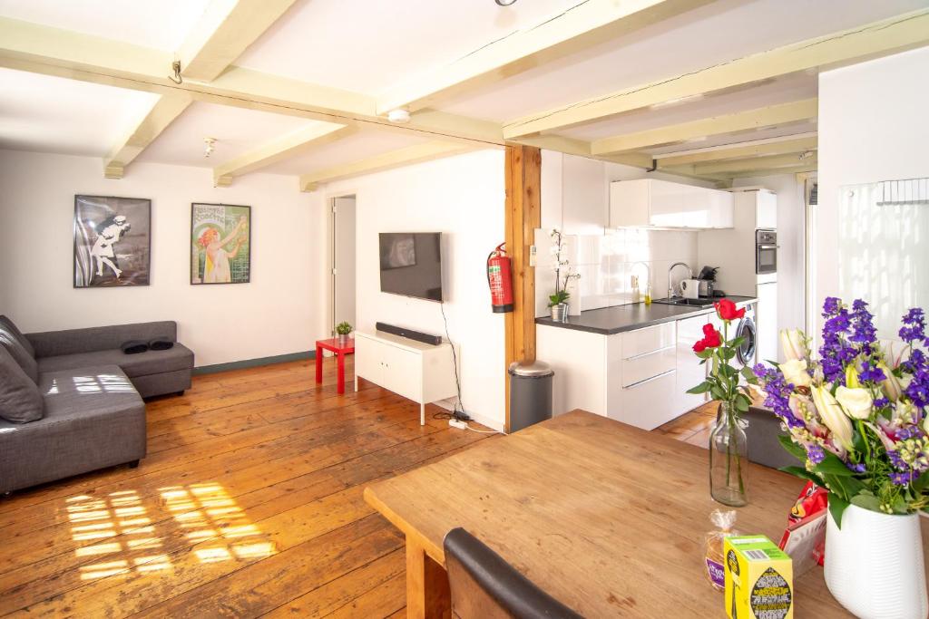 sala de estar con mesa y cocina en Spacious Central City Apartment with big private Sundeck!, en Ámsterdam