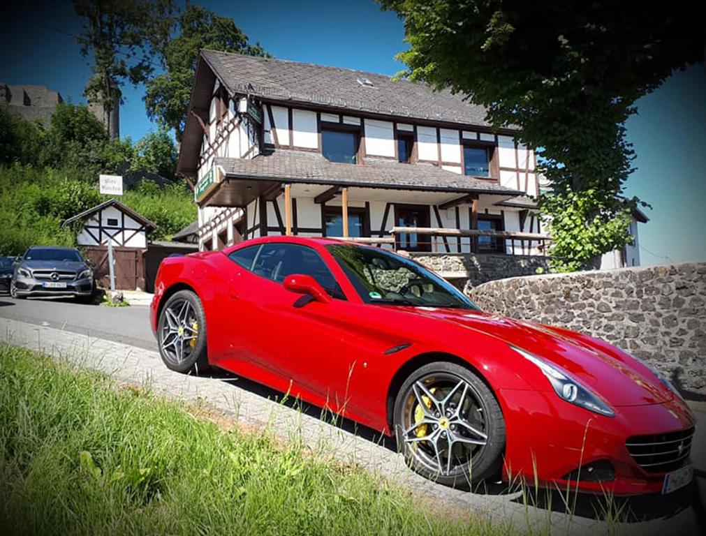 un coche rojo estacionado frente a una casa en DF am Ring Nürburg en Nürburg