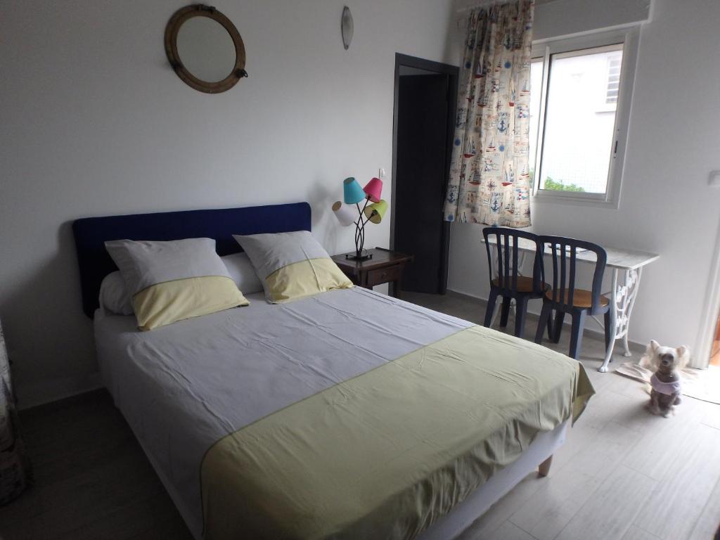 Un dormitorio con una cama y una mesa con un osito de peluche al lado. en La Marine, en Le Moule