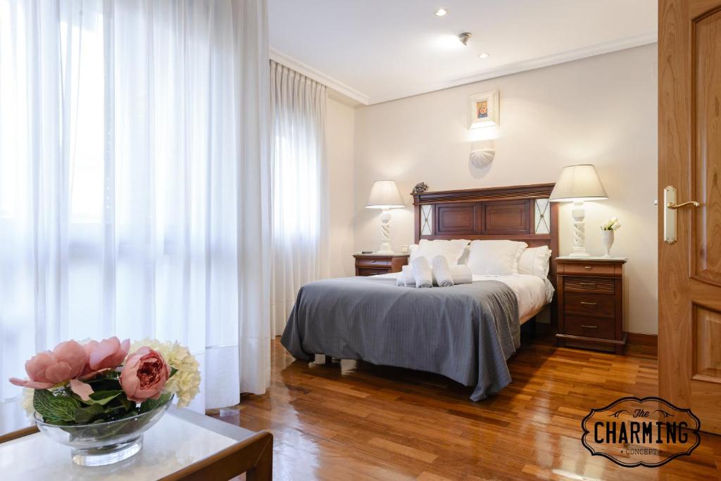 Un dormitorio con una cama y una mesa con un jarrón de flores en Charming Argüelles, en Madrid
