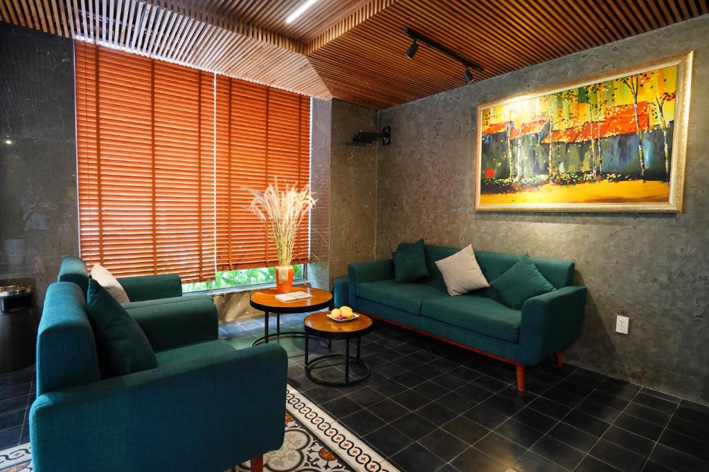 a living room with two blue couches and a painting at Lahome Villa Apartment in Danang