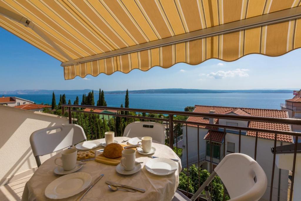 a table on a balcony with a view of the water at Two-Bedroom Apartment in Crikvenica XXXVI in Dramalj