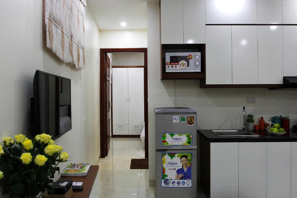 a kitchen with a refrigerator in the middle of a room at ISTAY Hotel Apartment 2 in Hanoi