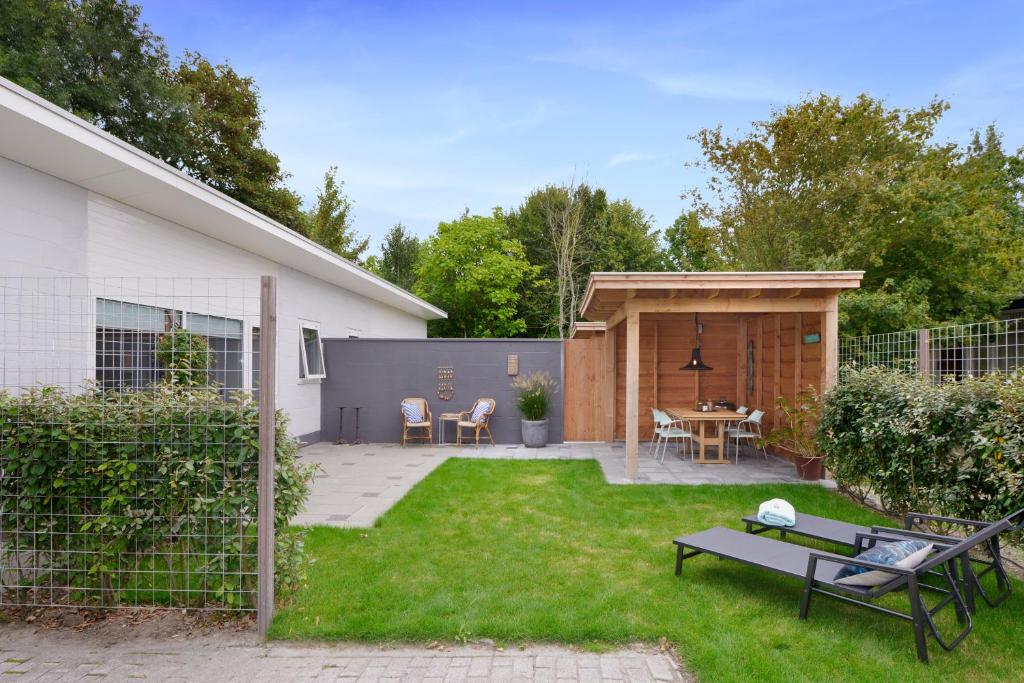 einen Hinterhof mit einem Picknicktisch und einem Schuppen in der Unterkunft Banjaard Beachhouse Patrijzenlaan 14 in Kamperland