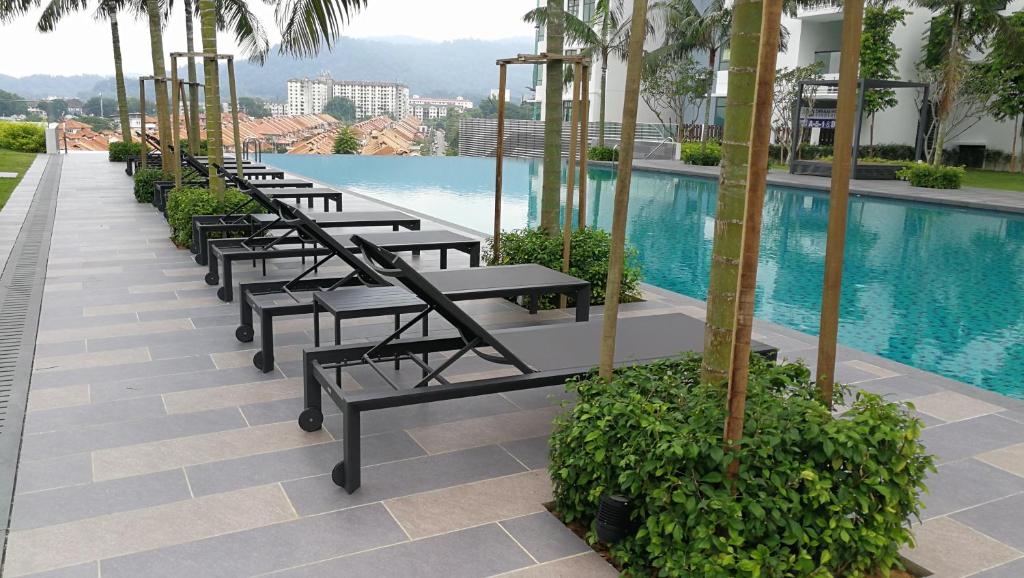 a row of benches sitting next to a swimming pool at EcoWoodz @ Kepong Residence in Kuala Lumpur