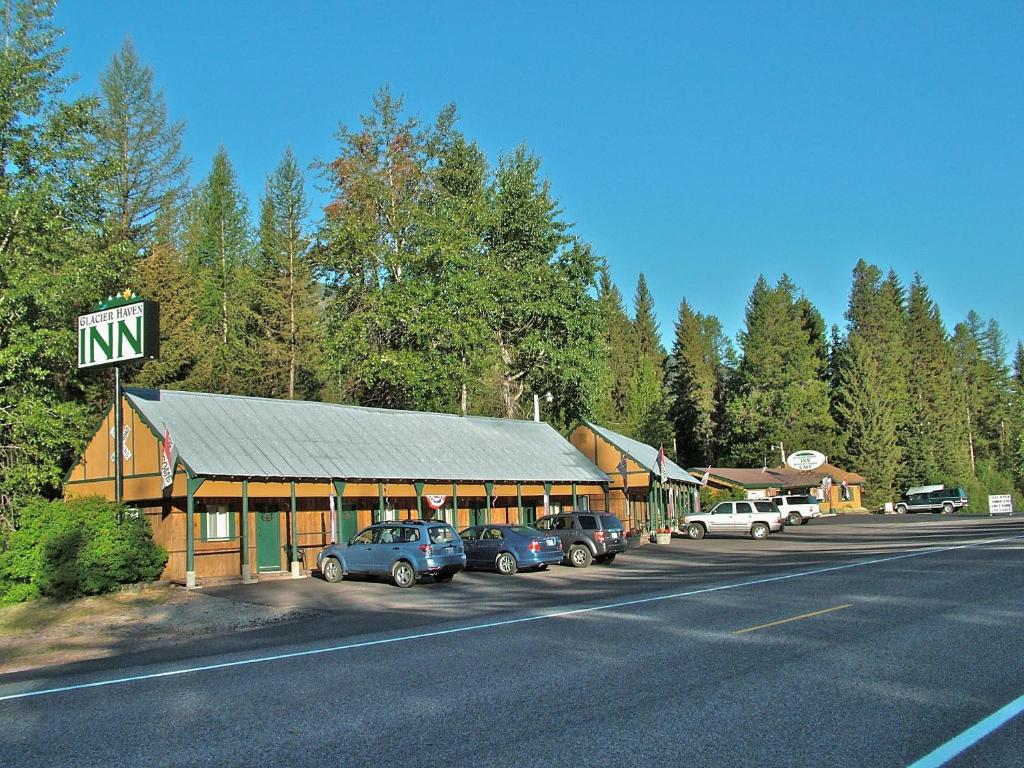 um edifício com carros estacionados num parque de estacionamento ao lado de uma estrada em Glacier Haven Inn em Pinnacle