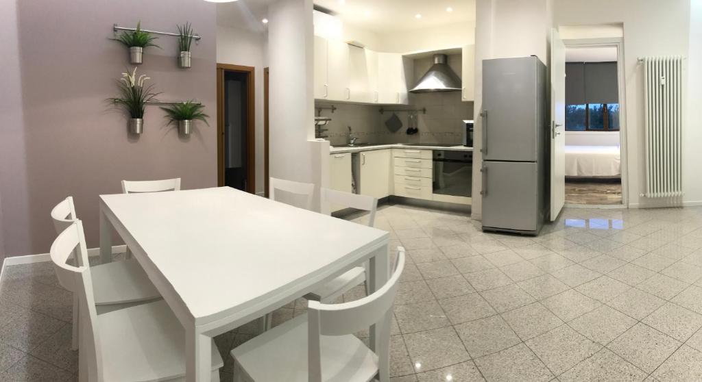 a kitchen with a white table and a refrigerator at Suite i Gessi in San Ruffillo