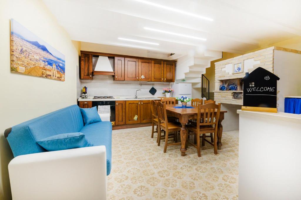 une cuisine et une salle à manger avec un canapé bleu et une table dans l'établissement B&b Lady Cristina, à Meta