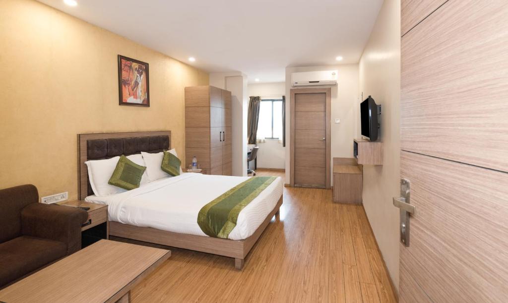 a hotel room with a bed and a couch at Treebo Trend Pal Comfort in Jamshedpur