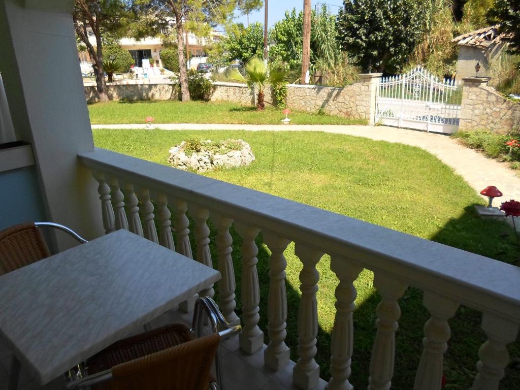 a balcony with a table and a view of a yard at Hotel Villa Basil in Tsilivi
