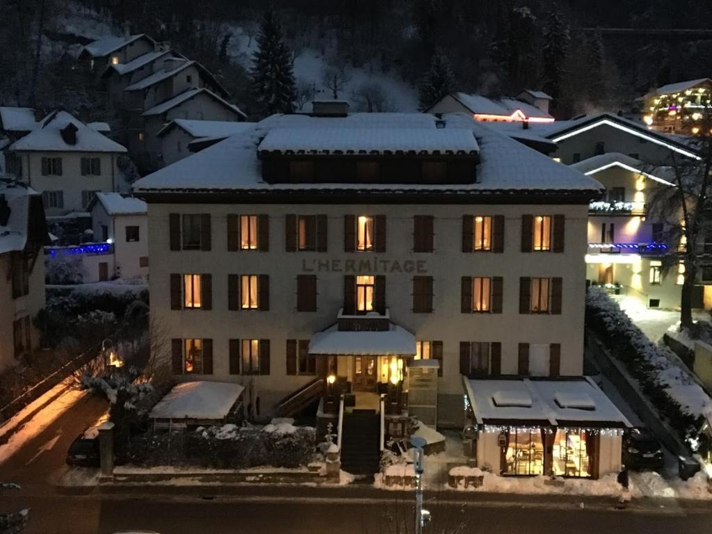 een groot gebouw met verlichting in de sneeuw bij L'Hermitage in Brides-les-Bains