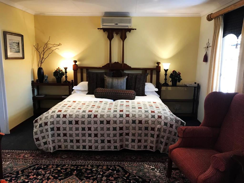 a bedroom with a large bed and two chairs at The Crown Guest House in Bethlehem
