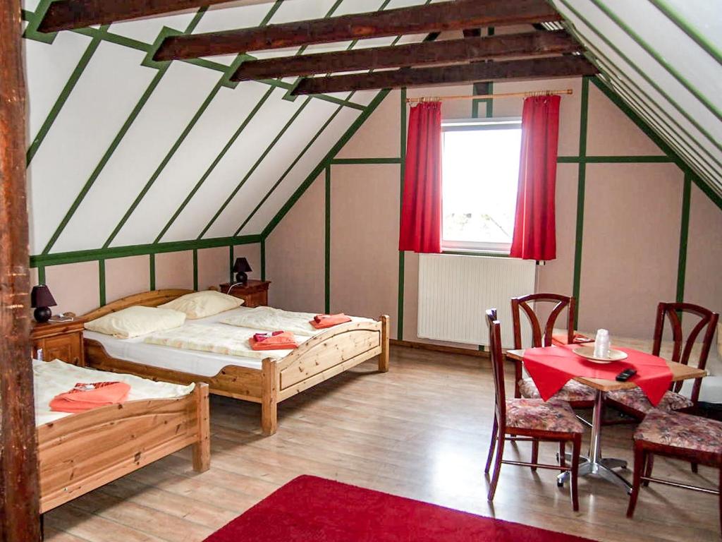 una camera da letto con due letti, un tavolo e delle sedie di Pension Haus Saarland a Oberhof