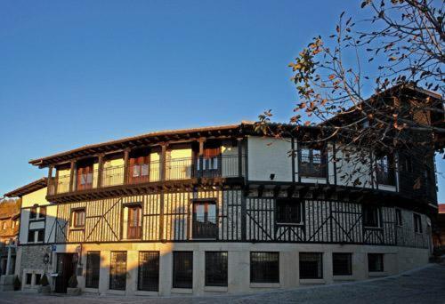 a large building with a balcony on top of it at Hotel Spa Villa de Mogarraz in Mogarraz