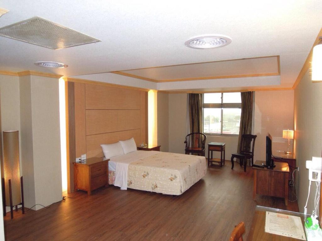 XiluoにあるSan Ho Business Hotelのベッドルーム1室(ベッド1台、テーブル、椅子付)