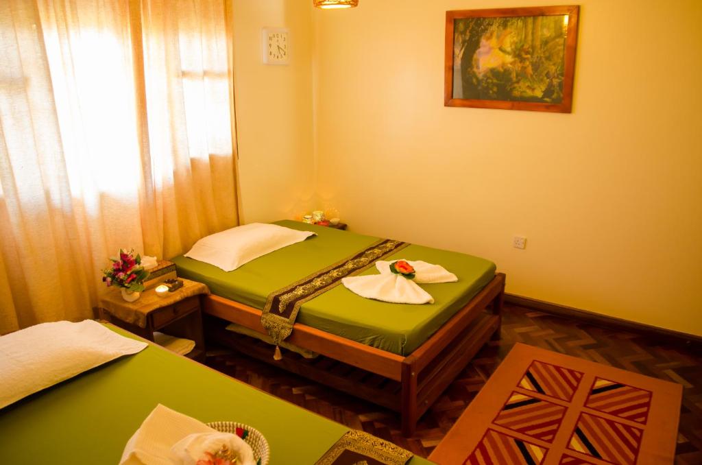Postel nebo postele na pokoji v ubytování Entebbe Palm Hotel