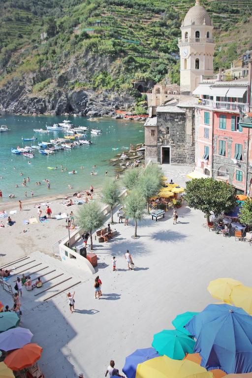 a group of people on a beach with umbrellas at MADA Charm Apartments Terrace&Carugio in Vernazza