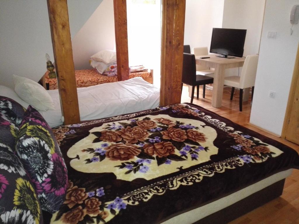 a bedroom with a bed with a flower pattern on it at Pešić Apartmani in Kušići