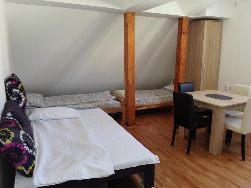 a room with a bed and a table and a table and chairs at Pešić Apartmani in Kušići