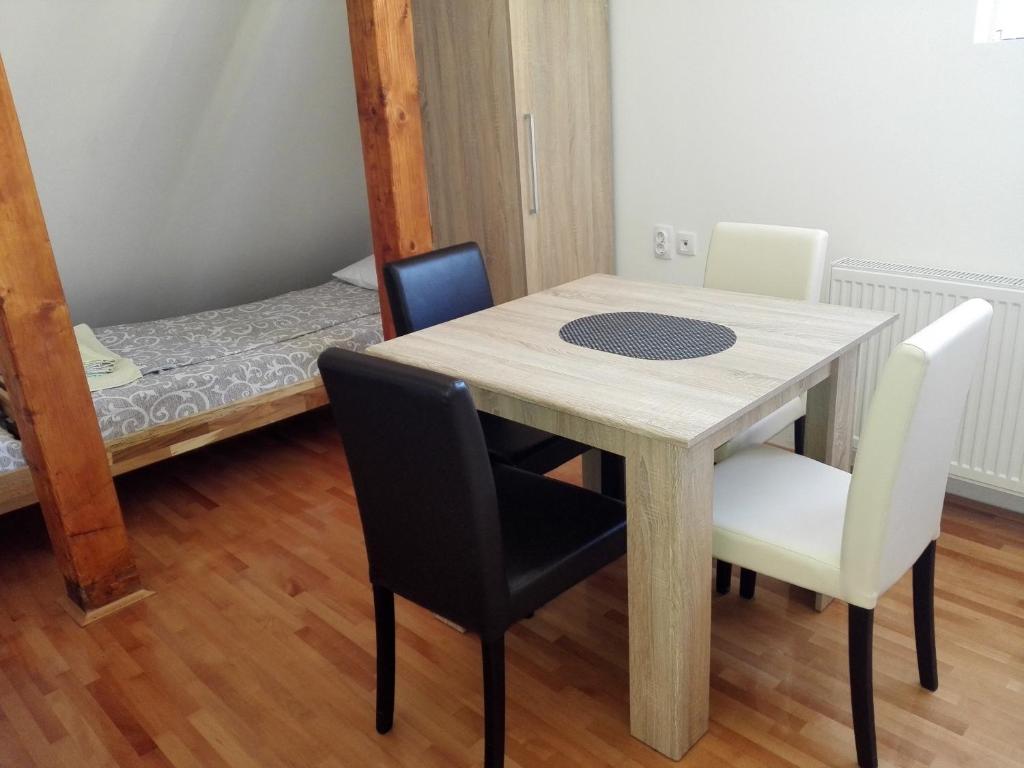 a table and chairs in a room with a bed at Pešić Apartmani in Kušići