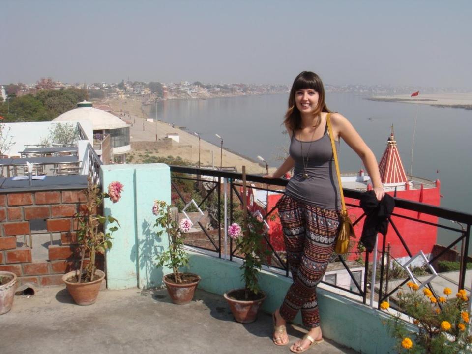 a woman standing on the ledge of a balcony at Rahul Guest House in Varanasi