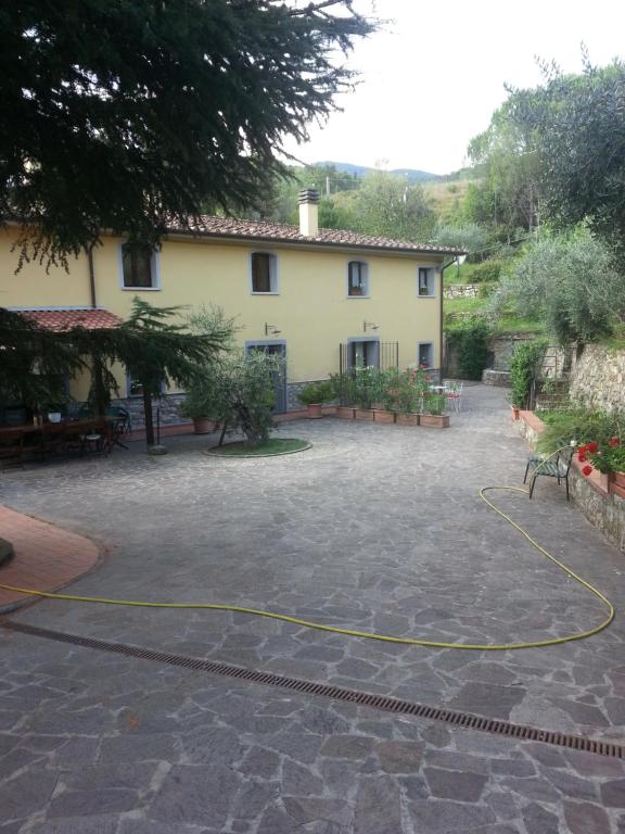 a building with a yellow hose in a courtyard at vacanza nel verde in Prato